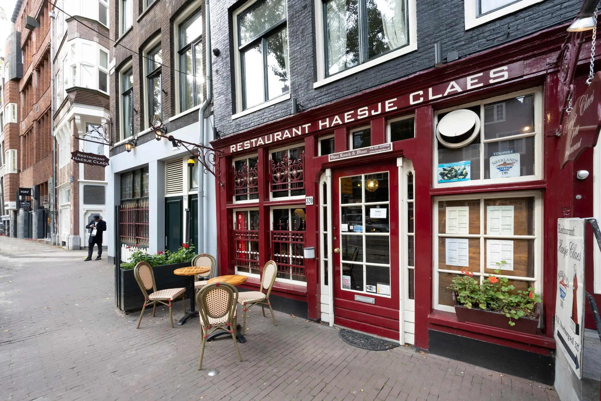 Gevel van restaurant Haesje Claes aan de Nieuwezijds Voorburgwal met buitenterras en klassieke rood-witte uitstraling.